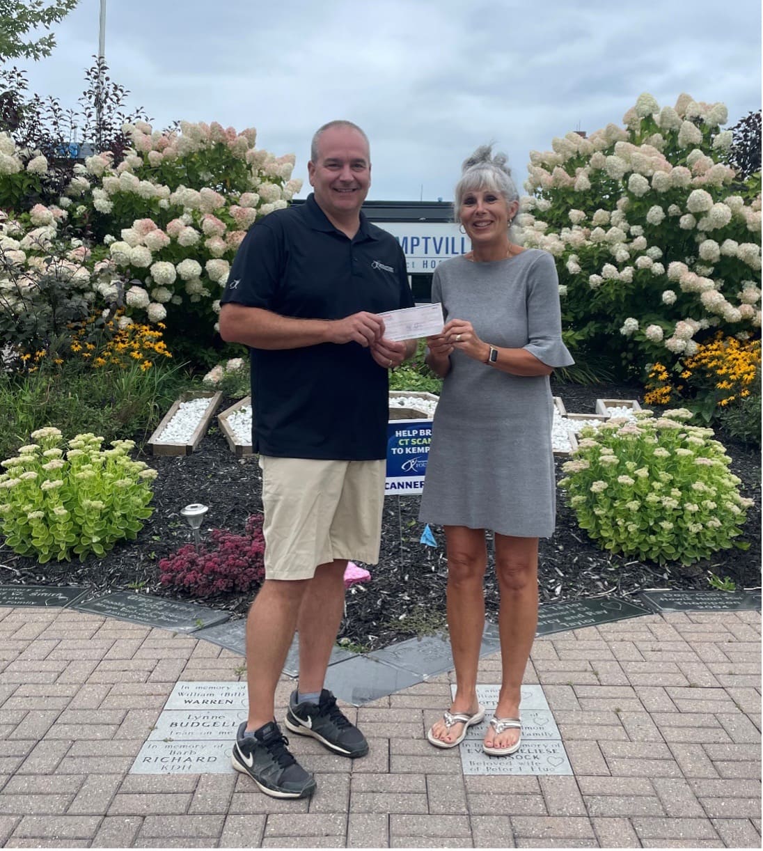 Pat Poirier, Foundation Director, receives from Judy Luttau the proceeds from the 2023 “Donate for  Dustin Golf Tournament”. 